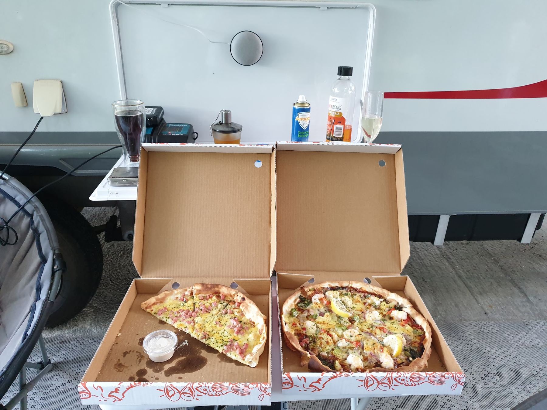 Two Blaze pizzas in their boxes, picked up and taken back to a caravan